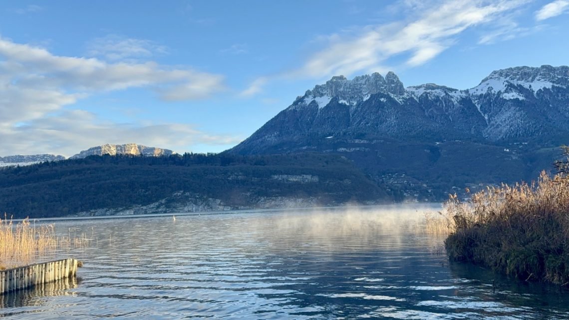 Lake Annecy with mountains in background on winter morning before cold water swimming session.