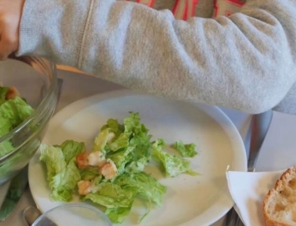 Toddler eating lunch at French daycare near Lake Annecy.