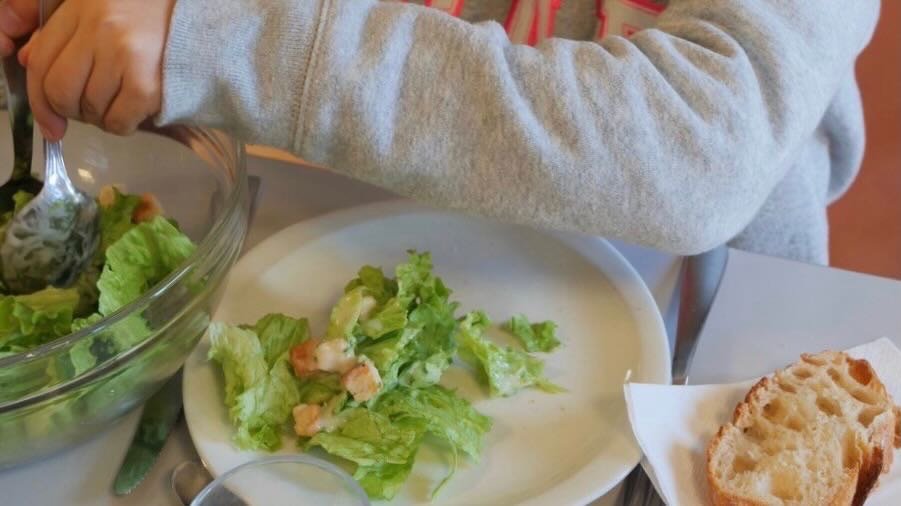 Toddler eating lunch at French daycare near Lake Annecy.
