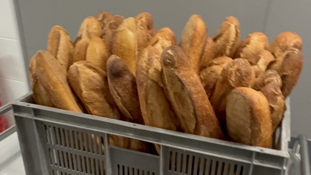 Crate of freshly baked baguettes delivered daily to a French school cafeteria.