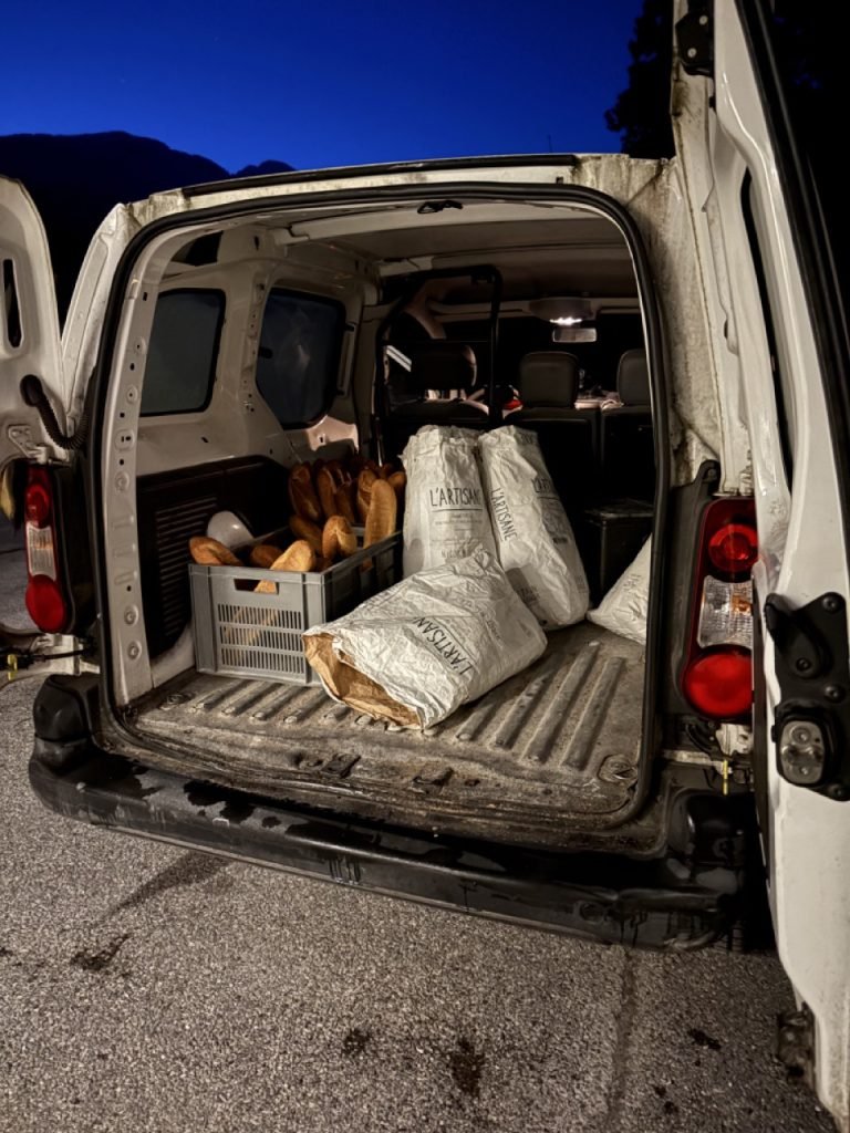 Delivery truck with fresh baguettes for French school lunch.