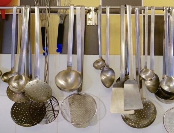 An assortment of hanging utensils on wall of French school cafeteria kitchen.