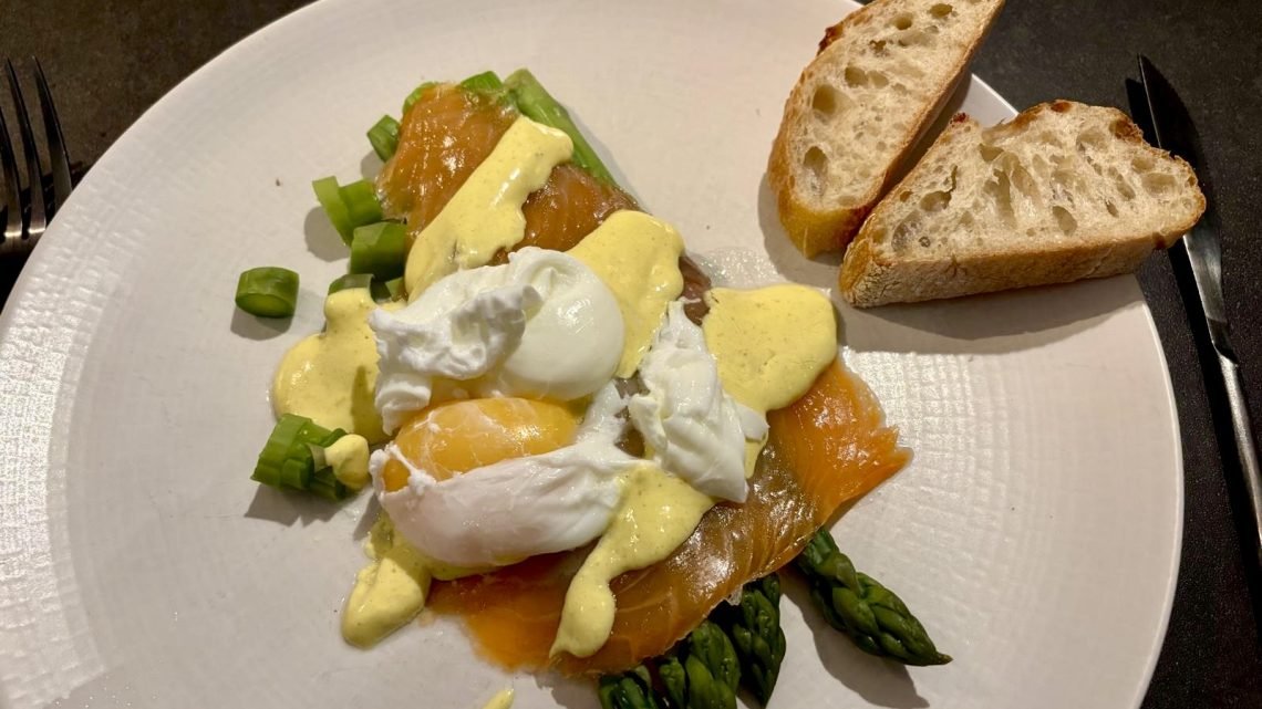 Typical dinner of fish, eggs, vegetables, french bread representing what French women eat in a day at dinner time