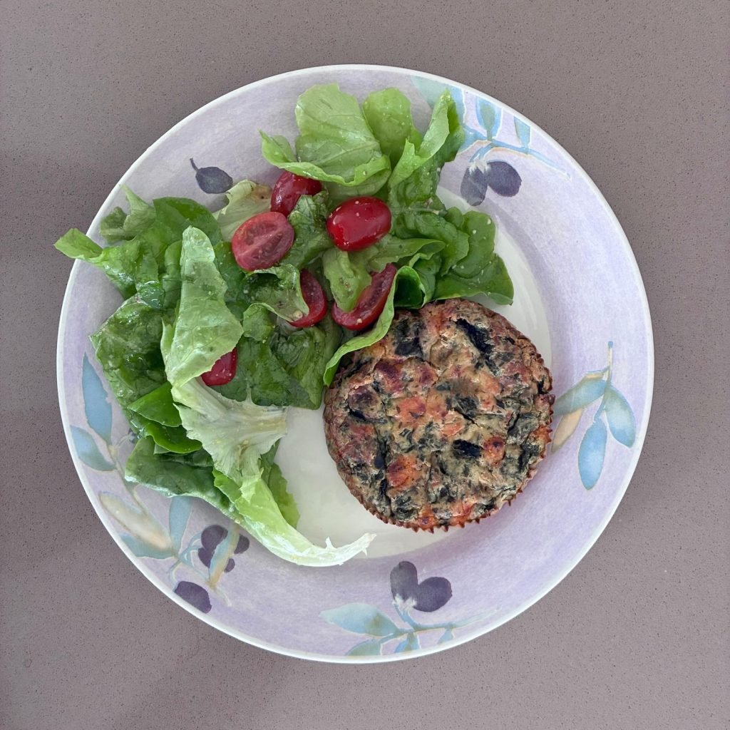 Green salad with cherry tomatoes served with a spinach and salmon quiche for lunch