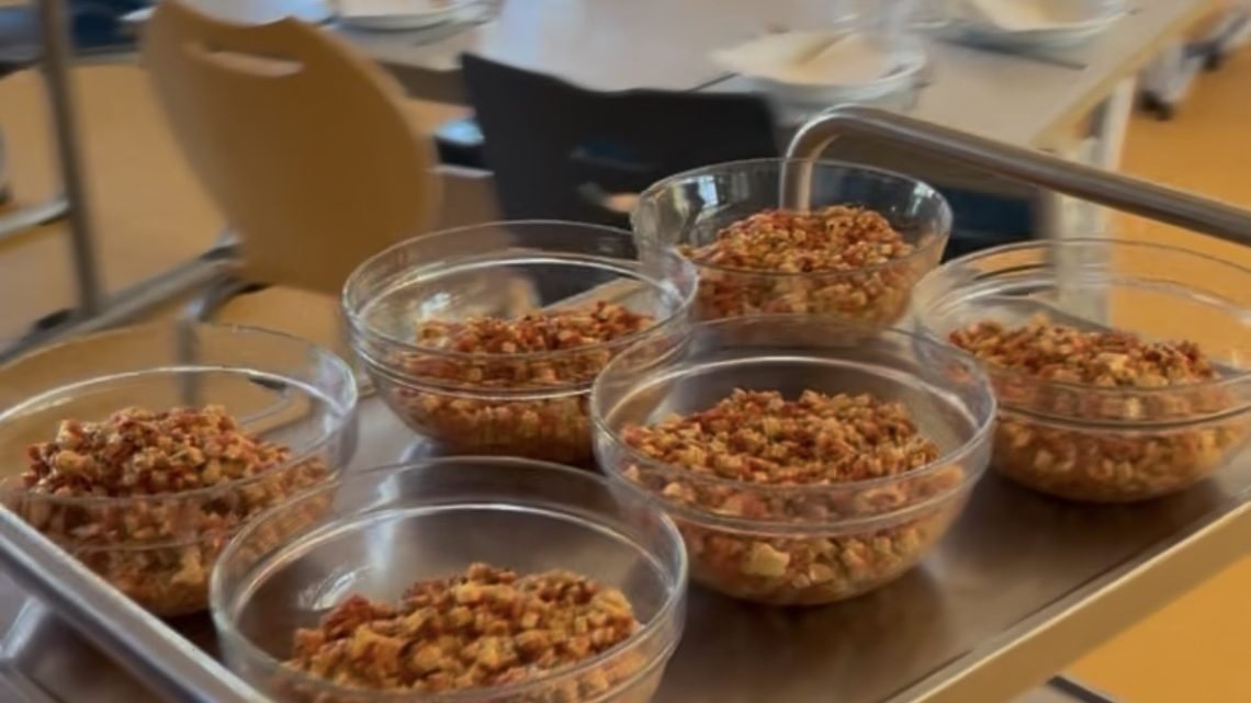 Glass bowls of prepared food ready to be served to children in a French school cafeteria.