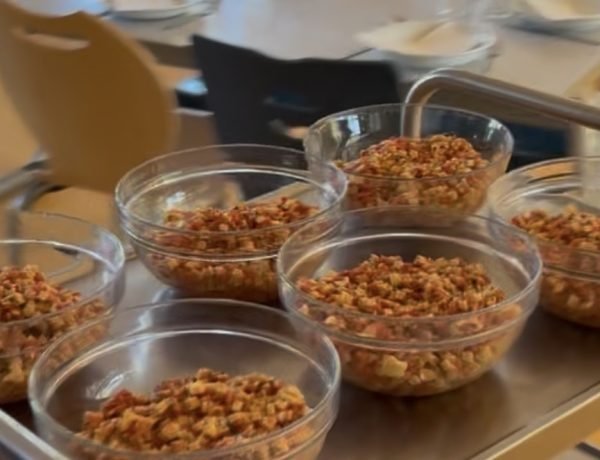 Glass bowls of prepared food ready to be served to children in a French school cafeteria.