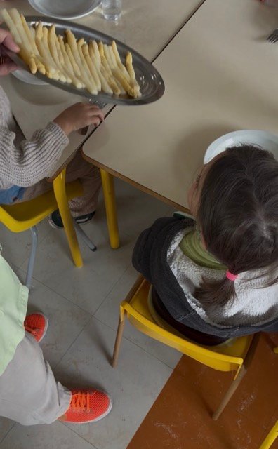 Three year olds being served asparagus for lunch in France